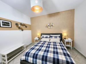 バーリにあるArco Alto Apartmentのベッドルーム1室(青と白のベッド1台、テーブル2台付)