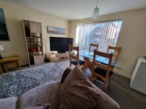 een woonkamer met een bank en een tafel met stoelen bij Moonbay apartment in Cardiff