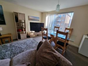 a living room with a couch and a table with chairs at Moonbay apartment in Cardiff