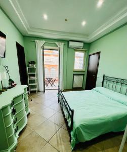 ein Schlafzimmer mit grünen Wänden, einem Bett und einem Fenster in der Unterkunft Napoli Sea View in Portici