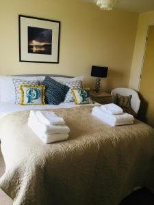 een slaapkamer met een bed met handdoeken erop bij Moonbay apartment in Cardiff