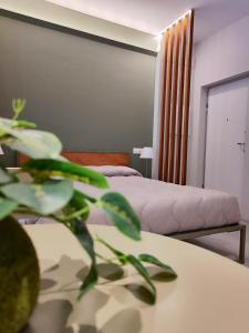 a bedroom with a bed and a table with a plant at CivitaNave in Civitanova Marche