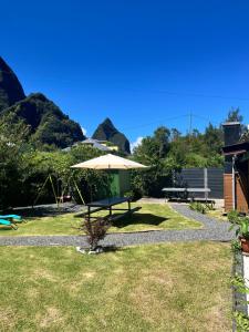 - une table de pique-nique avec un parasol dans l'herbe dans l'établissement Au Pied des Sources, à Cilaos