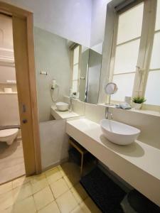 La salle de bains est pourvue de 2 lavabos et d'un grand miroir. dans l'établissement Nelli's B&B, à Cospicua