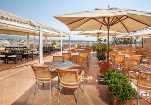 馬略卡島帕爾馬的住宿－加泰羅尼亞馬略卡酒店，一个带桌椅和遮阳伞的庭院