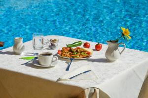 a table with a plate of food and a cup of coffee at Astir Of Naxos in Naxos Chora