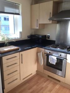 a kitchen with a stove top oven next to a window at Moonbay apartment in Cardiff