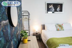 a bedroom with a bed and a table with a plant at Manchester Apartment with Free Gated Parking by Daley Stays in Manchester