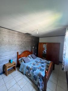 a bedroom with a bed and a table in it at Au Pied des Sources in Cilaos