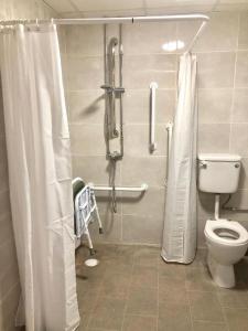 a bathroom with a toilet and a shower in it at Belvedere Hotel and Golf in Bridlington