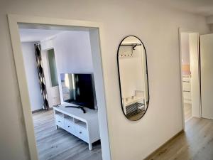a mirror on a wall next to a white dresser and a bathroom at Fewo Linz in Frensdorf