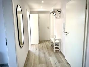a hallway with a mirror and a white wall at Fewo Linz in Frensdorf