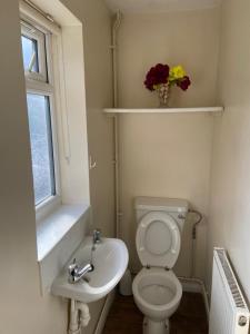 a bathroom with a toilet and a sink and a window at 14 Wallcourt Road in Biddenham