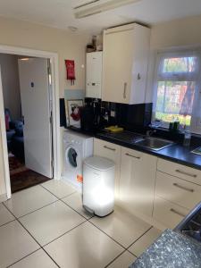a kitchen with a sink and a washing machine at 14 Wallcourt Road in Biddenham