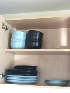 a shelf with bowls and plates in a kitchen at Moonbay apartment in Cardiff