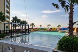 uma piscina num resort com palmeiras em ALH Vacay - Aykon City 2 Tower C - 2 bedrooms em Dubai