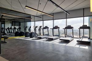 a gym with a row of treadmills and a large window at ALH Vacay - Aykon City 2 Tower C - 2 bedrooms in Dubai