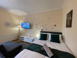 a bedroom with a bed and a tv on the wall at The Islington Hub in London