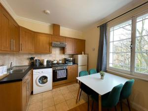 a kitchen with a table and a stove and a dishwasher at The Islington Hub in London