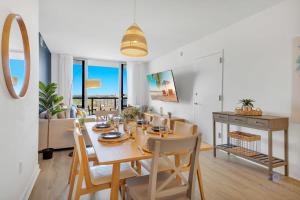 a dining room and living room with a table and chairs at Infinite Views, Amazing Pool, Gym, Near Beach in Hallandale Beach