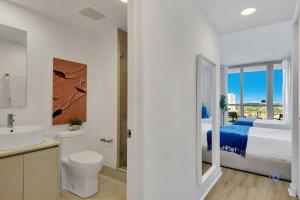 a white bathroom with a bed and a sink at Infinite Views Amazing Pool Gym in Hallandale Beach