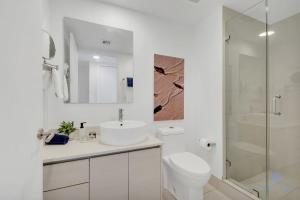 a white bathroom with a sink and a shower at Infinite Views Amazing Pool Gym in Hallandale Beach +30 photos