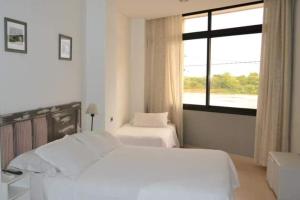 1 dormitorio blanco con 2 camas y ventana en Costanera Goya Apart & Hotel en Goya