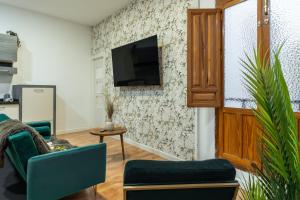 a living room with two chairs and a tv on a wall at tuGuest Cetti Meriem Apartment in Granada
