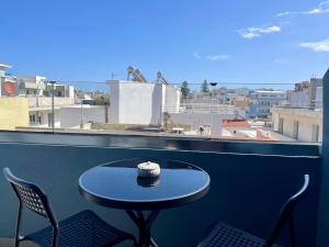 een tafel op een balkon met uitzicht op de stad bij Sea Side Rooms in Rhodos-stad