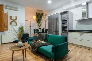 a living room with a green couch and a table at tuGuest Cetti Meriem Apartment in Granada +24 photos