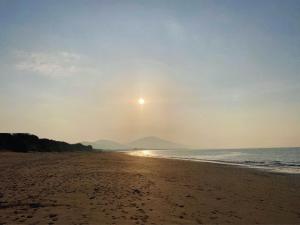 a beach with the sun rising over the ocean at The Ashe Hotel in Tralee