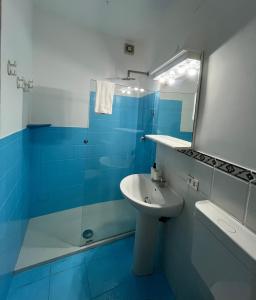 a blue bathroom with a sink and a mirror at Arco Sallustio 2.0 in Monopoli