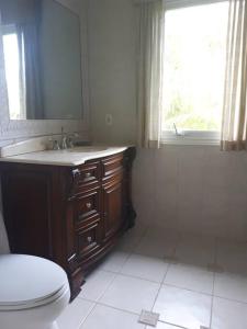 a bathroom with a toilet and a sink and a window at Oceanview at Coral Habour in Nassau