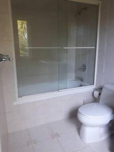 a white bathroom with a toilet and a shower at Oceanview at Coral Habour in Nassau