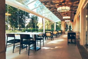 jadalnia ze stołem, krzesłami i oknami w obiekcie Estalagem Santa Iria Hotel & Spa w mieście Tomar