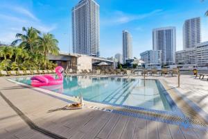 a large swimming pool with a city skyline in the background at Infinite View, Balcony, Gym, Amazing Pool in Hallandale Beach