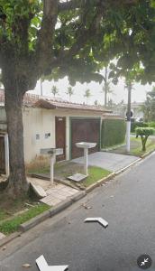 un tavolo da picnic e una panchina sul lato di una strada di Aluga-se casa com piscina a Guarujá
