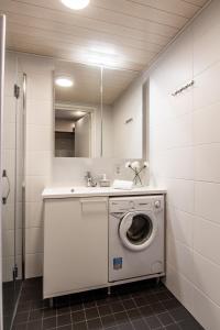 - un lave-linge dans la salle de bains pourvue d'un lavabo dans l'établissement Spot Apartments Tikkurila, à Vantaa