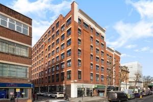 a tall red brick building on a city street at 2 bed Bethnal Green Penthouse in London