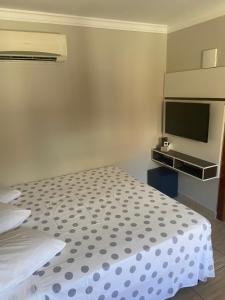 a bedroom with a bed and a flat screen tv at Residencial Cecilia Cruz in Bombinhas
