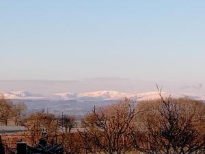 a person sitting on a horse looking at the mountains at Sunny Mount Glamping Pod in Long Marton