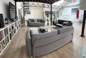 - un salon avec deux canapés et une télévision dans l'établissement LE FAUBOURG SAINT MARTIN, à Senlis