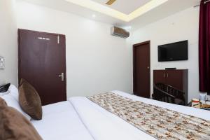 pokój hotelowy z 2 łóżkami i telewizorem w obiekcie Hotel Sunlight Inn w Nowym Delhi