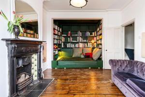 a living room with a fireplace and a couch at Hackney - Victoria Park Generous 2 Bed Terrace in London