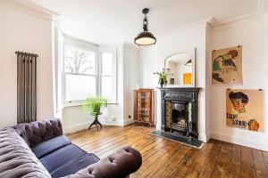 a living room with a couch and a fireplace at Hackney - Victoria Park Generous 2 Bed Terrace in London