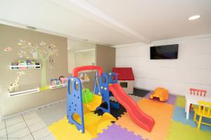 a childrens play room with a slide and swings at Promenade Palladium Leblon in Rio de Janeiro