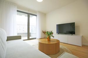Una sala de estar con un sofá y un televisor. en Aurora Apartments, en Bratislava