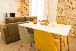 a dining room with a white table and yellow chairs at Torre Solana 41 in Cádiz