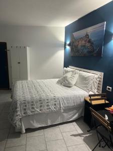 um quarto com uma cama branca e uma parede azul em Ca Du Grifun 2 em Vernazza