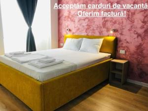 a bedroom with a large bed with a yellow frame at Happy Apartments Mamaia Nord -2 Dormitoare in Mamaia Sat/Năvodari